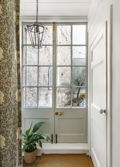 an entryway with a potted plant in front of the door and a window