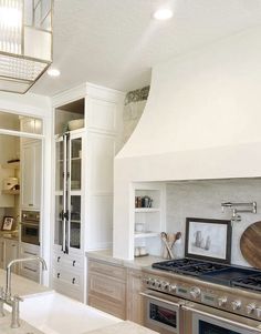 a kitchen with an oven, stove and sink in it's center island area