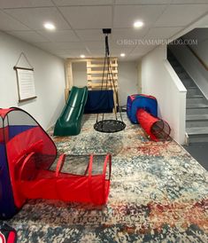 an indoor play area with slides, swings and climbing equipment for children to climb on