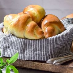 bread rolls in a basket on a cutting board