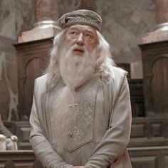 an old man with long white hair and beard standing in front of pews at a church