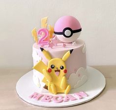 a pokemon themed birthday cake with pikachu and poke - oo on top