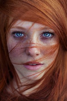 a woman with red hair and blue eyes