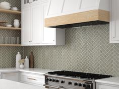 a stove top oven sitting inside of a kitchen next to white cupboards and counter tops