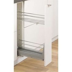 an open cabinet door in a kitchen with wooden floors and white walls, showing the bottom drawer