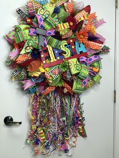 a colorful wreath with numbers and ribbons hanging on a door