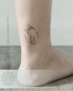 a small cat tattoo on the ankle is shown in black and grey ink, with an outline