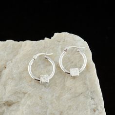 This pretty pair of Cube Charm Sterling Silver Hoops are handcrafted for you with great care from high-quality 925 Sterling Silver hand-hammered charms. The earrings are easy to put on and perfect for everyday wear. MATERIALS AND SIZE  ◆ Metal - 925 Sterling Silver ◆ Hoop Size is 15 mm / 0.59 inches from the top to bottom  GIFT AND PACKAGING ◆ All jewelry is packed beautifully in a branded gift box. ◆ If the item is intended as a gift, please pick the gift option at the checkout. A free personal Handmade Minimalist Small Hoop Wrap Earrings, Minimalist Handmade Hoop Wrap Earrings, Handmade Minimalist Small Hoop Earrings, Handmade Minimalist Huggie Hoop Earrings, Minimalist Handmade Huggie Hoop Earrings, Modern Handmade Huggie Earrings For Gifts, Modern Handmade Huggie Earrings Gift, Modern Handmade Huggie Earrings, Modern Handmade Huggie Earrings For Everyday