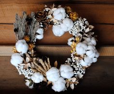 a wreath made out of cotton and pine cones