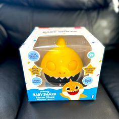 a yellow baby shark alarm clock sitting in a box