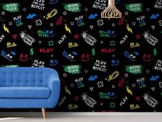 a blue couch sitting in front of a black wall with colorful letters and arrows on it