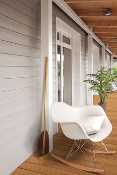 a white rocking chair sitting on top of a hard wood floor next to a door