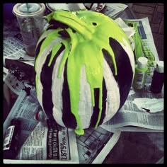 green and black striped pumpkin sitting on top of newspaper