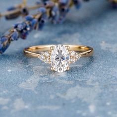 a close up of a ring on a blue surface with lavender flowers in the background