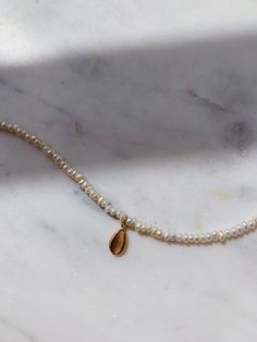 This gorgeous dainty natural pearls anklet comes with gold plated sterling silver shell pendant charm. Wear it on it's own or layer with other anklets in our collection. Pearls are symbolic of wisdom gained through experience. The gems are believed to offer protection, as well as attract good luck and wealth. Pearls are symbolic of the wearer's loyalty, generosity, integrity, and purity The surface of the pearls may have few bumps and ridges that indicate the natural origin of the pearls. The an Gold Pearl Anklets As Gift, Gold Pearl Anklets For Gift, Dainty Pearl Gold Anklets, Gold Pearl Anklet With Pearl Charm, Gold Anklets With Pearl Charm For Gift, Gold Anklets With Pearl Charm As Gift, White Anklets With Pearl Charm As Gift, Gold Dainty Anklets With Pearl Charm, Dainty Gold Anklets With Pearl Charm