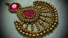 a brooch with beads and a pink bead on it's back end