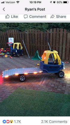 a small trailer with lights on it parked next to a fence and some other toys