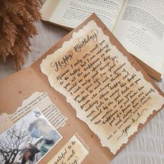 an open book with pictures and writing on it next to a pine cone filled with leaves