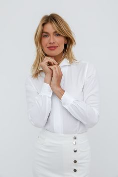 WHITE PIQUE FABRIC This intricate square pique texture reminds us of the most lavish and cozy bed linens—richly indulgent yet gloriously comfortable. 100% Italian Cotton Trying to decide on the perfect white shirt? Check out the Sarah Alexandra White Collection Shirt Guide! THE SIGNATURE SHIRT The Signature Shirt is fashioned with our innovative and fully shapeable one-piece collar for dramatic styling. Pop it high, create an alluring angle, or lay it flat—just follow your mood. The concealed fr Timeless White Button-up Blouse, Timeless White Workwear Tops, Timeless White Tops For Work, Timeless White Tops For Workwear, Classic White Blouse With Fold-down Collar, Classic White Blouse With Fold Down Collar, Timeless White Blouse For Work, Elegant White Blouse With Fold Down Collar, Elegant White Spread Collar Top