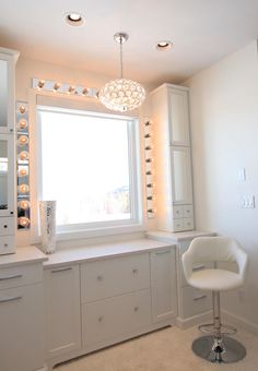 a white chair sitting in front of a window next to a dresser and counter top