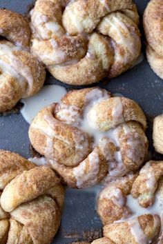 cinnamon rolls with icing sitting on top of a table