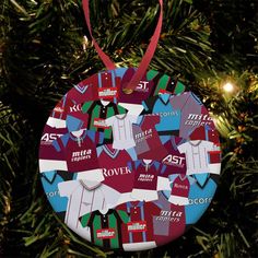 an ornament hanging from a christmas tree decorated with various shirts and polo collars