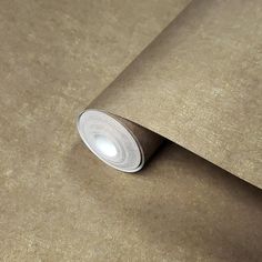 a roll of brown paper sitting on top of a table next to a light bulb