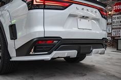 the rear end of a white suv parked in front of a stop sign