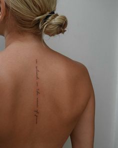 the back of a woman's upper body with writing on her left shoulder and right arm