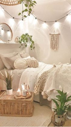 a white bedroom with plants and lights on the ceiling