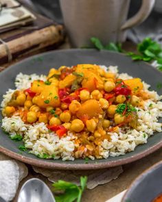 a plate with rice and chickpeas on it next to a cup of coffee