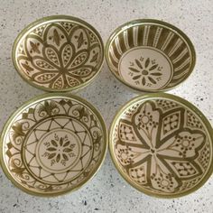 four decorative bowls sitting on top of a table