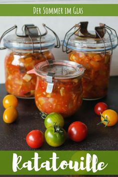 three jars filled with different types of food on top of a table next to tomatoes and peppers