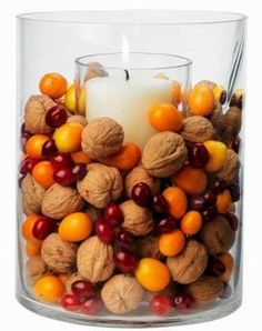 a glass filled with nuts and a candle