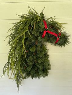 a horse head made out of branches and red ribbon