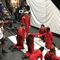 a group of people in red suits sitting on the ground