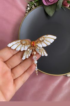 I made a white and gold color Dragonfly brooch for you and for your lovers gift Made with high quality materials like swarovski pearls, italian sequins, steel needle,swarovski bi cone,gemstone etc... There is a unbreakable and stainless steel needle back of brooch I sewed all materials one by one with great love Size is about 2.75 inches (7 cm) You can send me message for your special questions I can make your personalized design as a brooch or pendant Don't miss discount over 200 Usd White Butterfly Brooches For Gifts, Handmade White Wedding Pins, Embroidered Gold Brooches As Gifts, Gold Embroidered Brooches For Gifts, Gold Embroidered Brooch For Gift, Ornament Embroidery, Bug Jewelry, Embroidery Brooch, Dragonfly Brooch