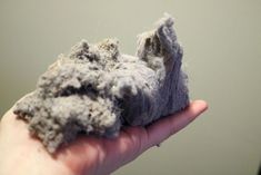 a hand holding a piece of gray rock