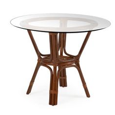 a round glass table with rattan legs and a wooden frame around the top, on an isolated white background