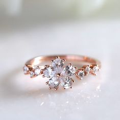 a rose shaped diamond ring on a white surface