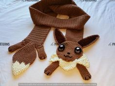 a crocheted scarf with a stuffed animal on it's side and instructions for how to knit the scarf