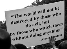 a person holding a sign that says the world will not be destroyed by those who do evil, but by those who watch them without doing anything