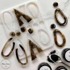 some scissors and other items on a white counter top with black stuff around them that says aoa