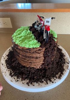 a cake made to look like dirt with a motorbike on top