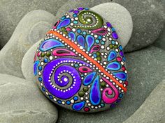 a colorful rock sitting on top of a pile of rocks