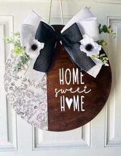 a door hanger that says home sweet home with flowers and ribbon on the front