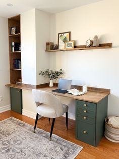 a desk with a laptop computer on top of it next to a chair and rug