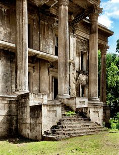 an old building with columns and steps leading up to the front door in black and white