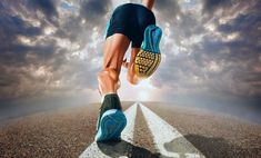 a man is running on the road with his feet in the air and clouds behind him