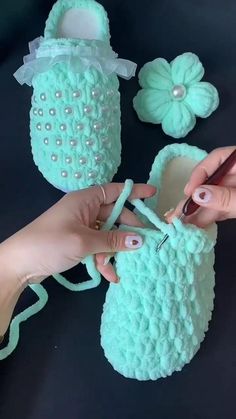 someone is crocheting something on top of a pair of slippers with scissors